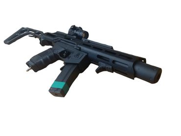 Black tactical airsoft gun with scope and folding stock isolated on white.