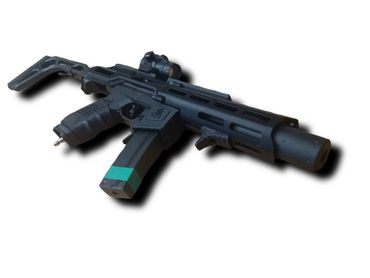 Black tactical airsoft gun with green tape on magazine and red dot sight.