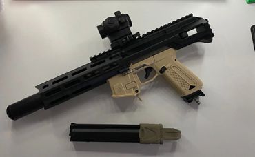 Compact firearm with tan and black design and a detachable magazine.