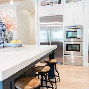 Modern white kitchen featuring large marble island.