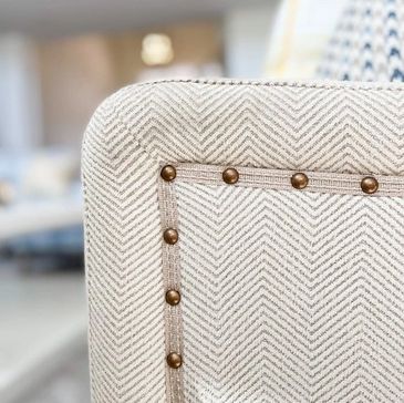 Close-up of patterned upholstery with brass studs.
