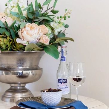 Floral centerpiece on table with wine glass.