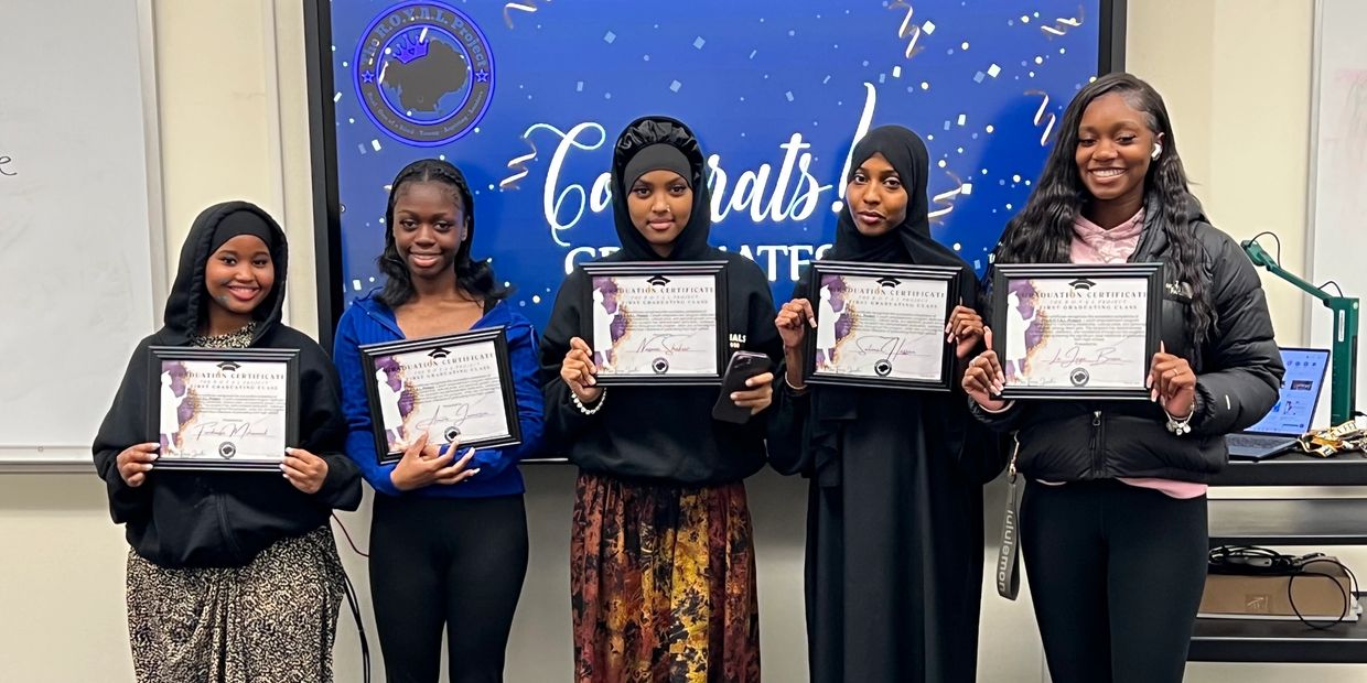 Five women holding graduation certificates and smiling.
