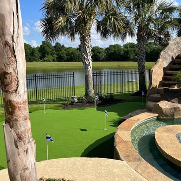 Large putting green with a pool and lake view