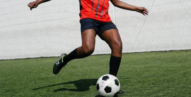 An athlete kicking a soccer ball