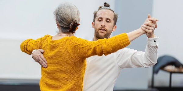 Dance instructor Bradley Xander ballroom dancing with a student.