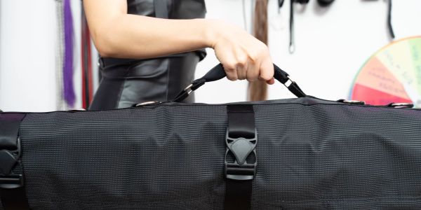 Person holding a black bag handle.