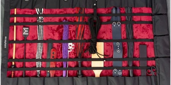Various BDSM gear laid out on a red velvet mat.