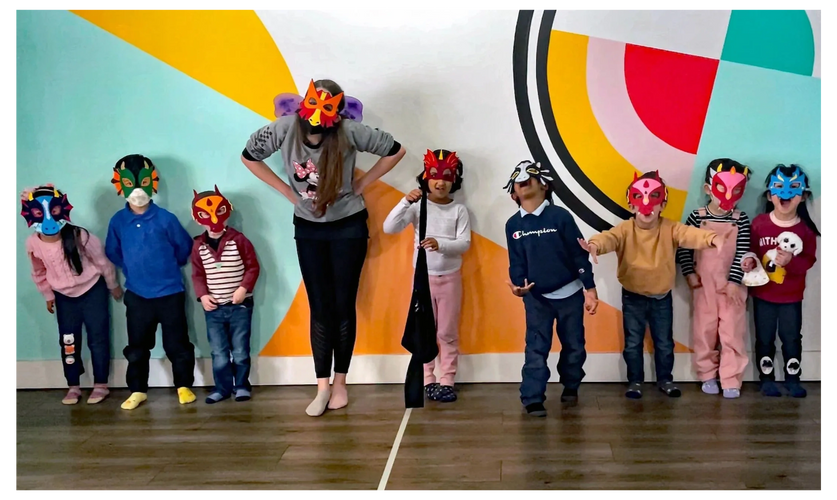 A group of children wearing dragon masks.