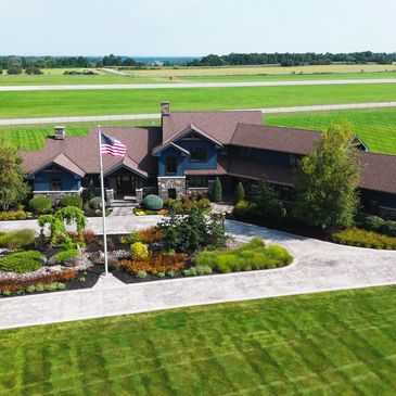 a large house with a well kept lawn and curved driveway