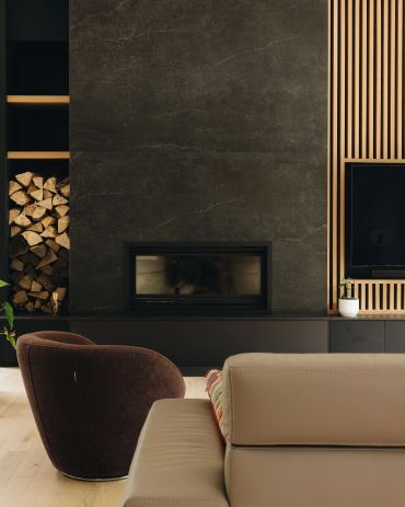Modern living room with fireplace and wood storage.