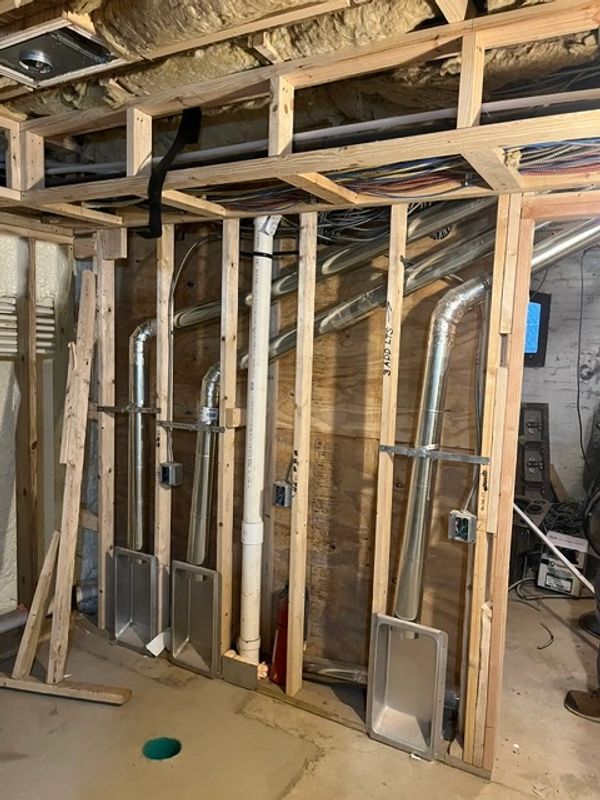 Framing and ductwork in a basement under construction.