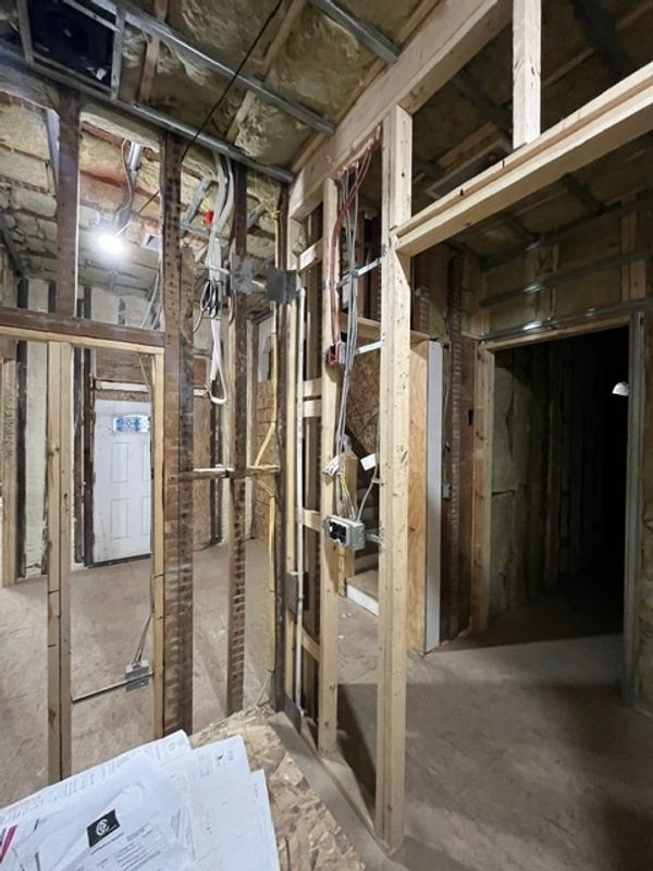 Interior of a house under construction with exposed framing and wiring.