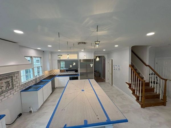 Modern kitchen under renovation with taped countertops.