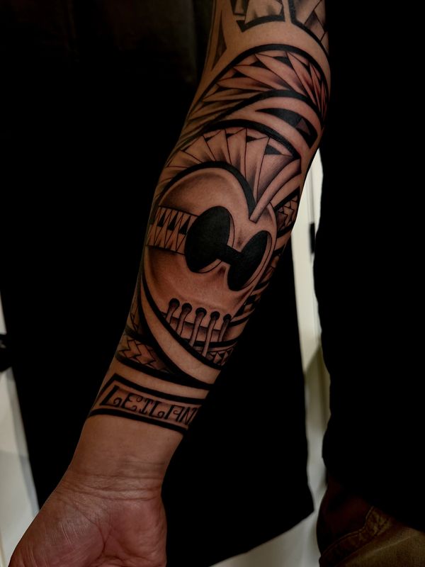Intricate blackwork tattoo of a stylized skull on forearm.
