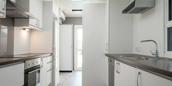 Bright, modern kitchen with white cabinetry and stainless appliances.