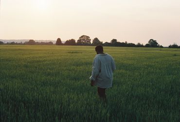 mann auf Feld im Sonnenuntergang
