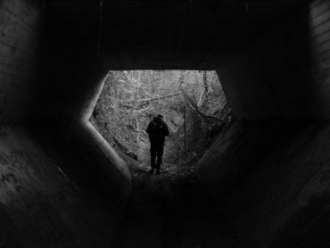 mann steht im Tunnel auf schwarz weiß