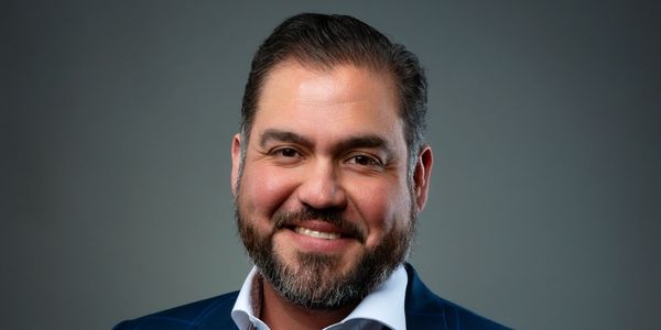 Smiling man with beard in suit.