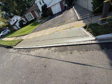 Freshly poured concrete sidewalk section cordoned off with caution tape.
