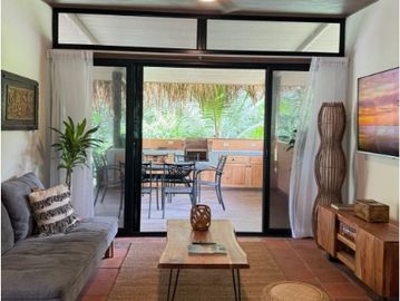 Cozy living room with natural decor and sliding glass doors to a lush patio.