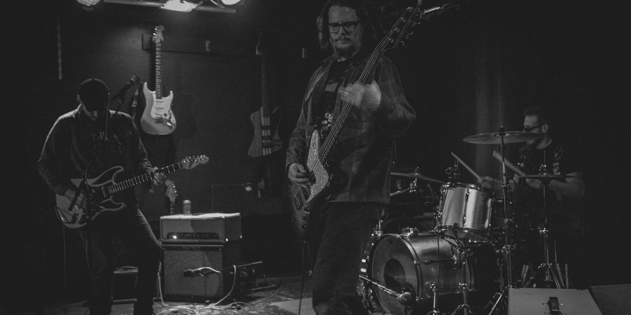 Black and white photo of a band playing live on stage.