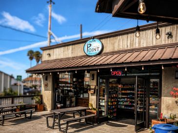 Outdoor view of a small store named "The Point" with picnic tables outside.
