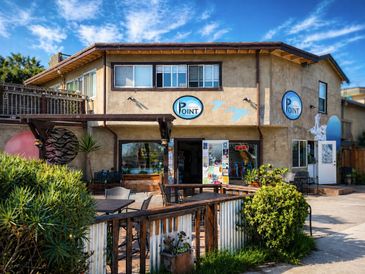 Cozy two-story building with a café named Point under a clear blue sky.