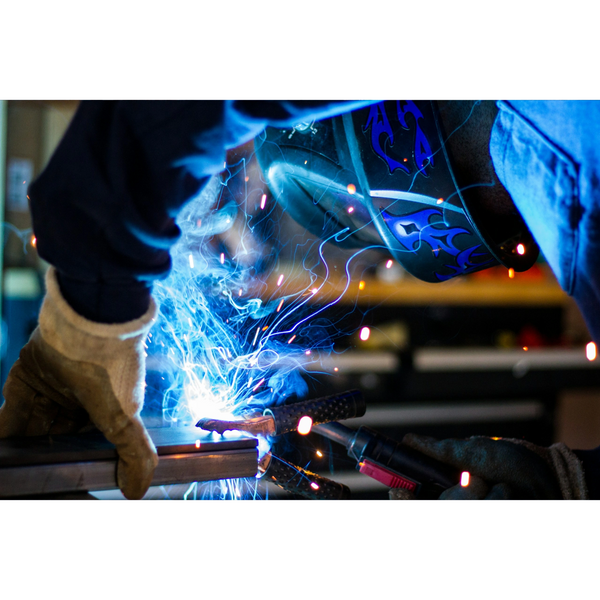 Close-up of a welder creating sparks while working on metal.
