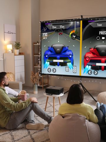 Friends gaming on projector screen at home