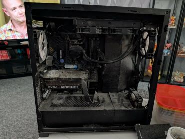 Dusty open PC case with components inside.
