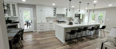 Modern white kitchen with island and bar stools.