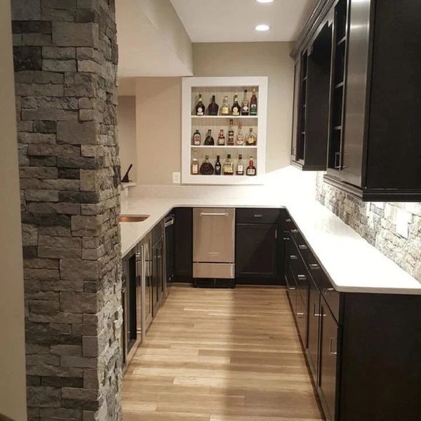Modern kitchen with stone wall and liquor display.