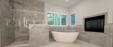 Modern bathroom with bathtub, shower, and fireplace.