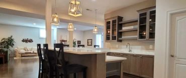 Modern kitchen with island and high chairs.