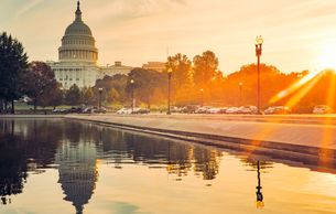 Sunset over the Capitol building with its reflection in the water.