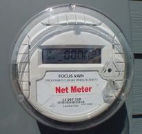 Close-up of an electric net meter showing energy usage.