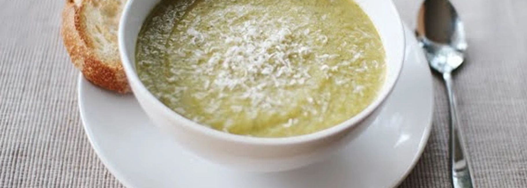 A bowl of broccoli and stilton soup with bread