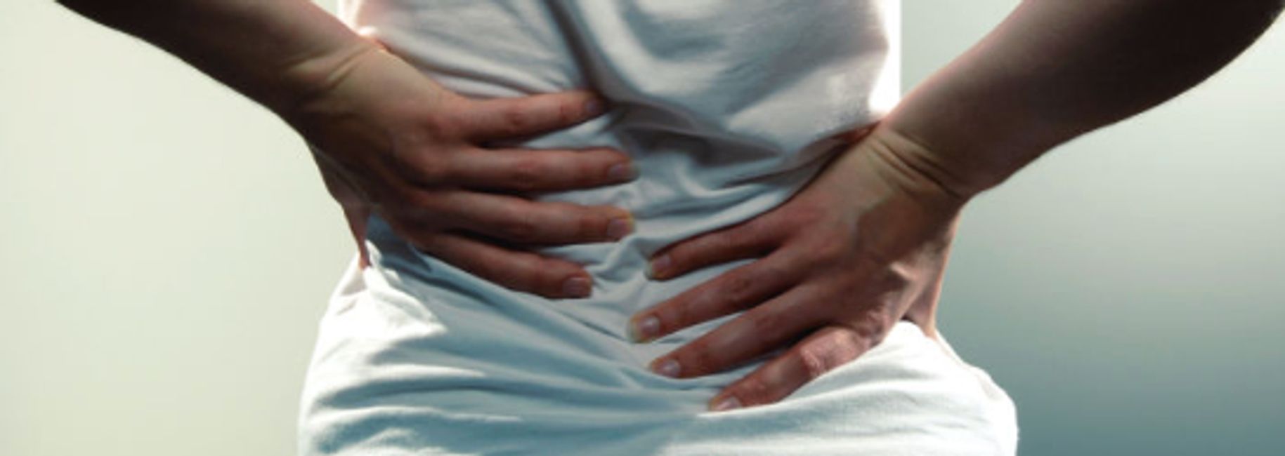 Woman suffering from back pain in Dee Why on Sydney's Northern Beaches