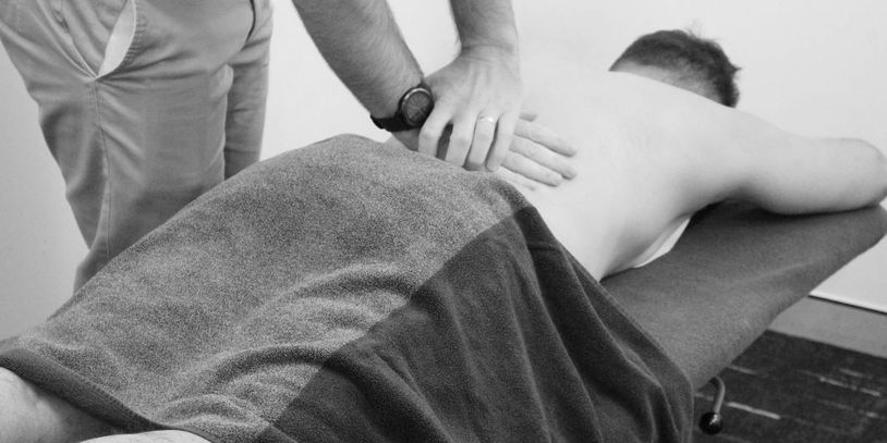 A person receiving a back massage while lying on a table.