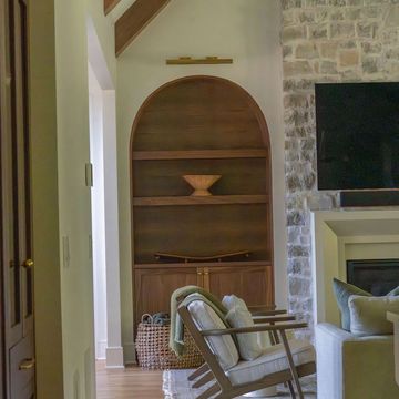 Wooden bookshelf with a decorative bowl in a cozy living room.