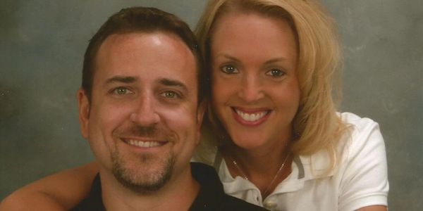 Smiling couple posing together in a studio portrait.