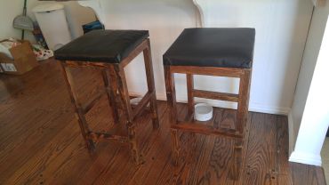 Pair of stools with walnut stain and memory foam top.