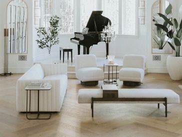 Bright modern living room with white furniture and grand piano.