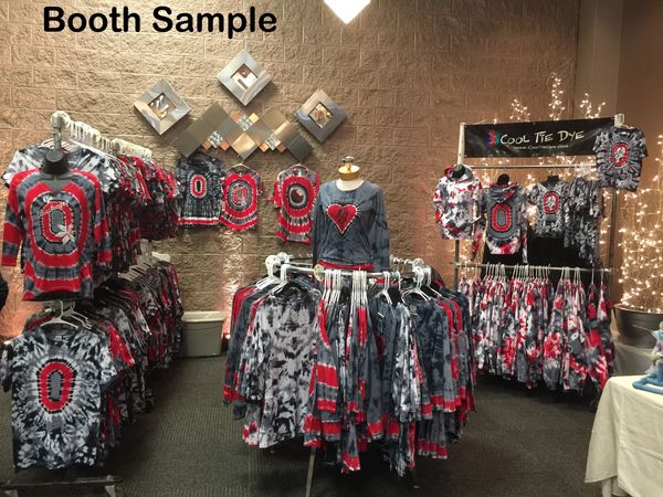 Tie-dye clothing booth with red, black, and gray designs on display.