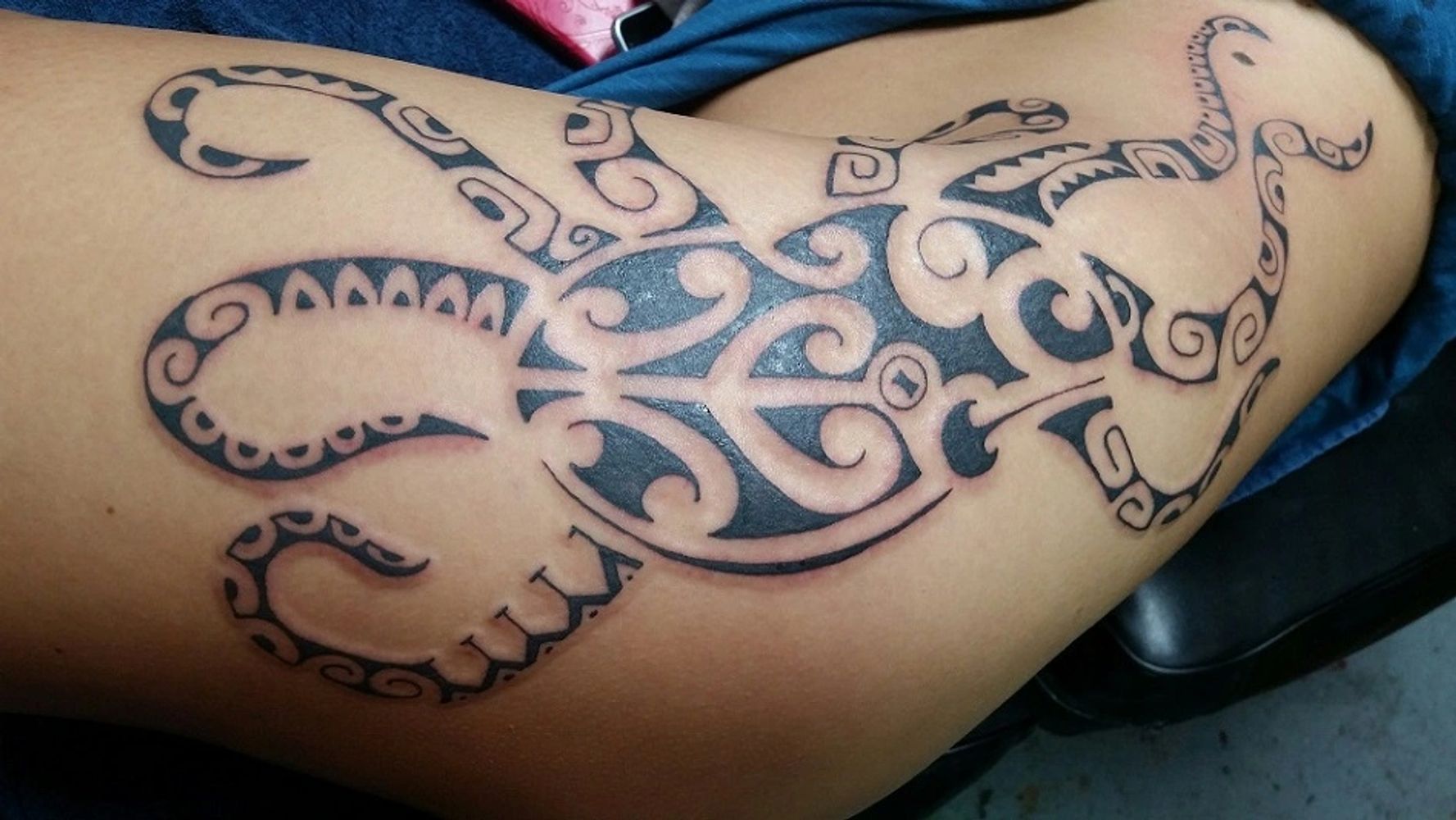 Polynesian octopus tattoo on hip and ribs by Rockwood.
