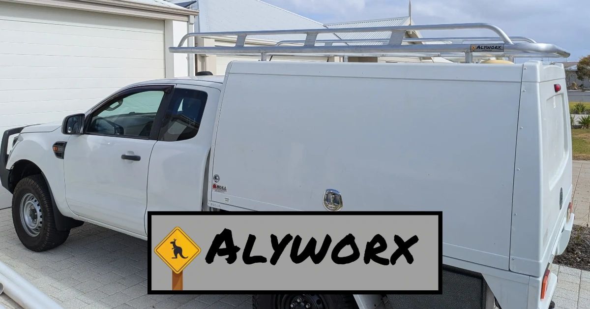 White utility truck with Alyworx roof rack in a residential driveway.