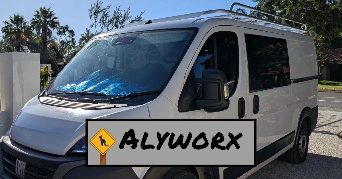 White cargo van parked outdoors with a reflective sunshade inside.