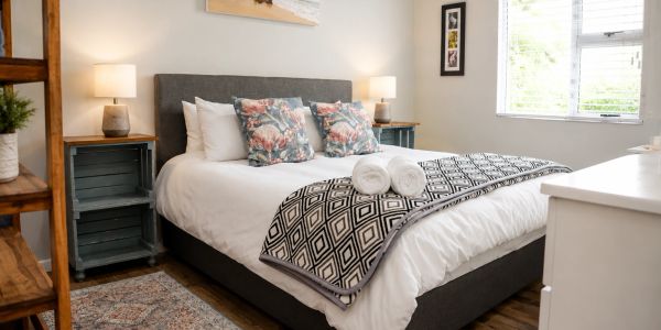 Cozy bedroom with a neatly made bed and decorative pillows.