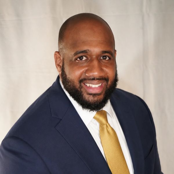 Man in suit smiling at the camera.